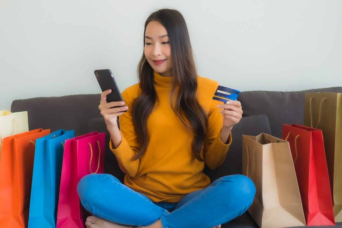 portrait-young-asian-woman-using-laptop-computer-with-smart-mobile-phone-credit-card-online-shopping