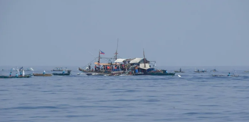 从菲律宾海岸警卫队船只 BRP Bagacay 的船头看到，菲律宾渔民与民间领导的“Atin Ito（这是我们的）”联盟的志愿者一起抵达南海的一个集合点。 5月15日，菲律宾渔船上的平民驶向东南亚国家附近中国控制的珊瑚礁，向菲律宾渔民分发物资，并维护他们对有争议水道的权利。