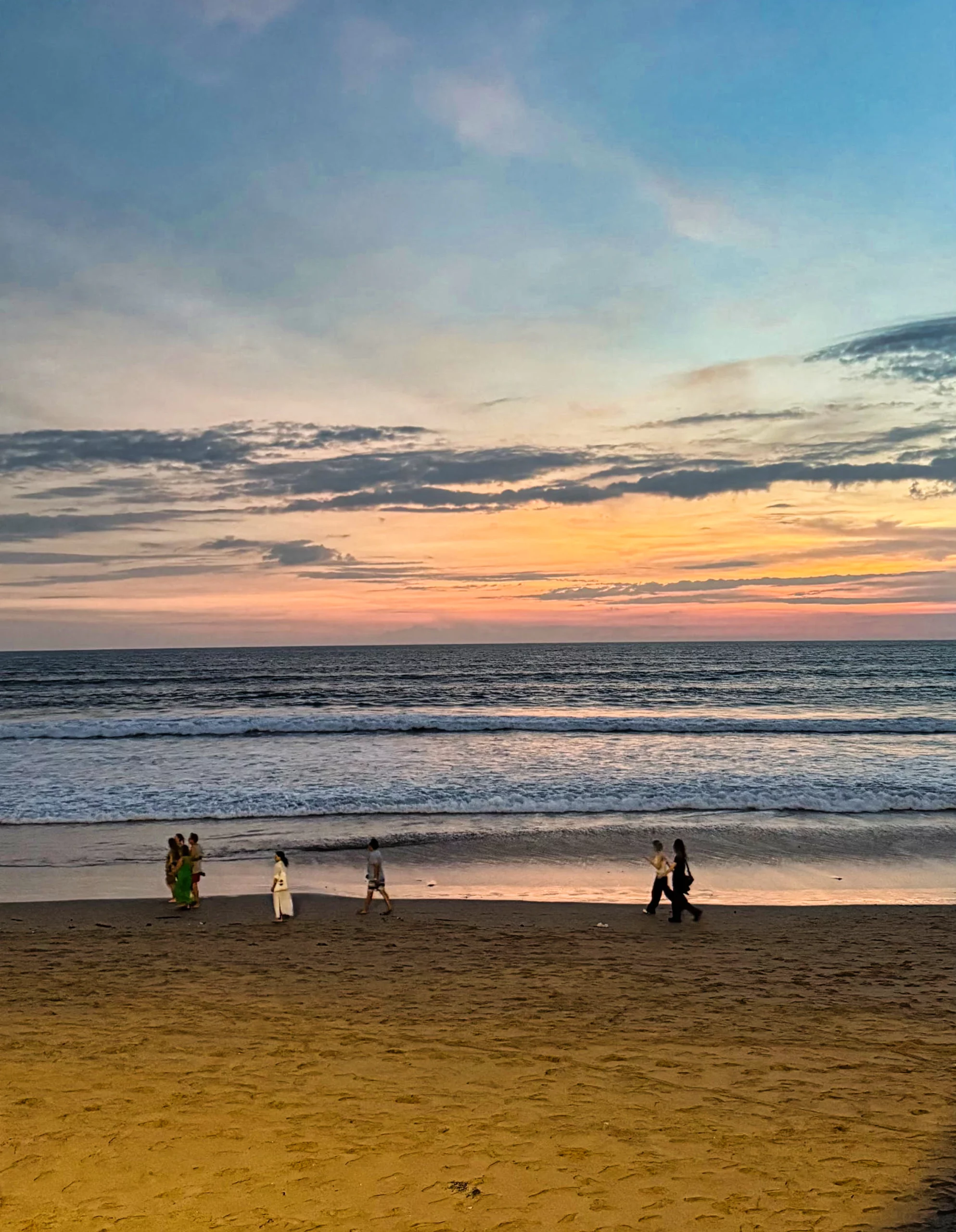 Couple strolling on Seminyak beach at night