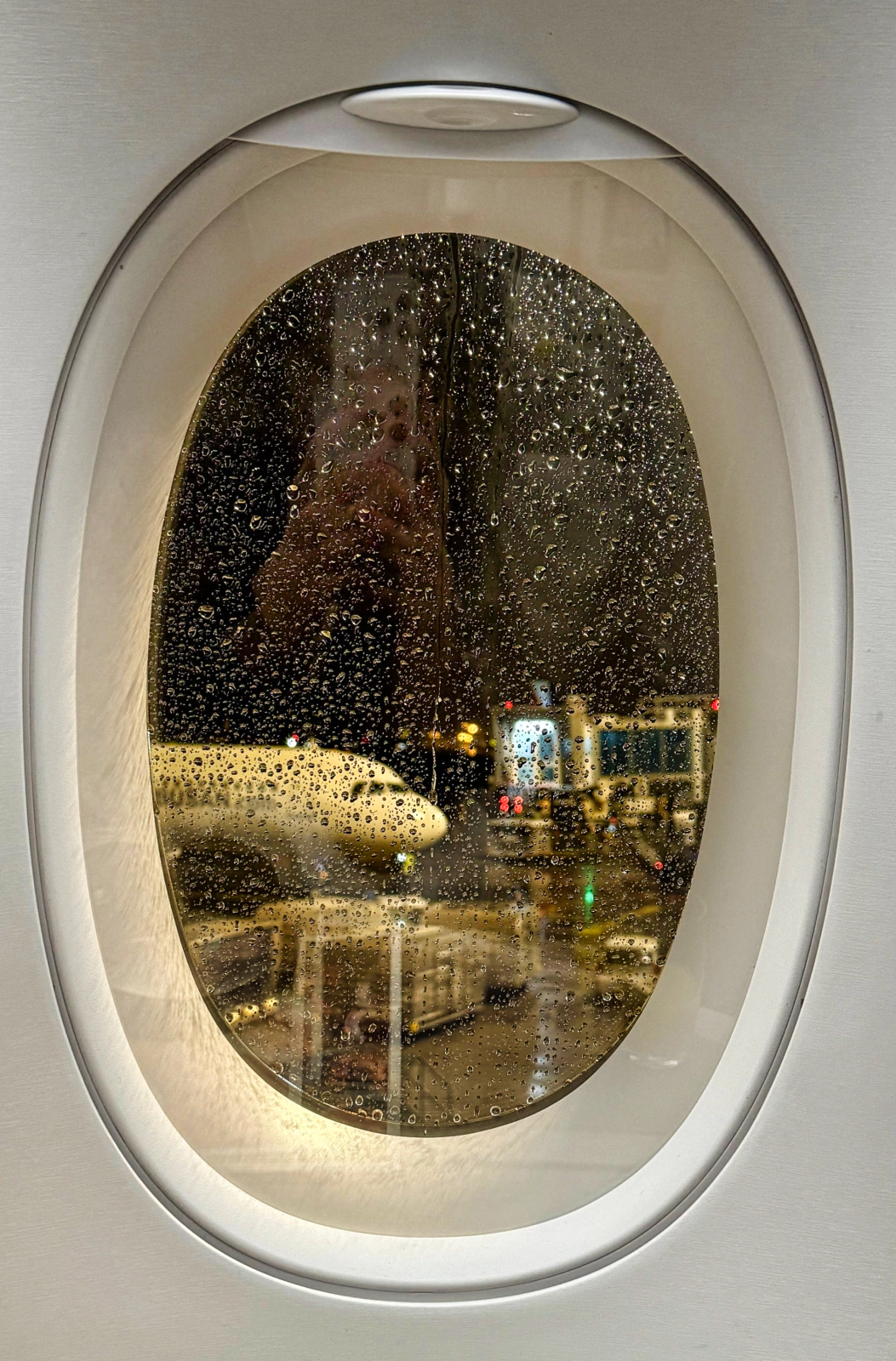 Airplane window with view from business class seat
