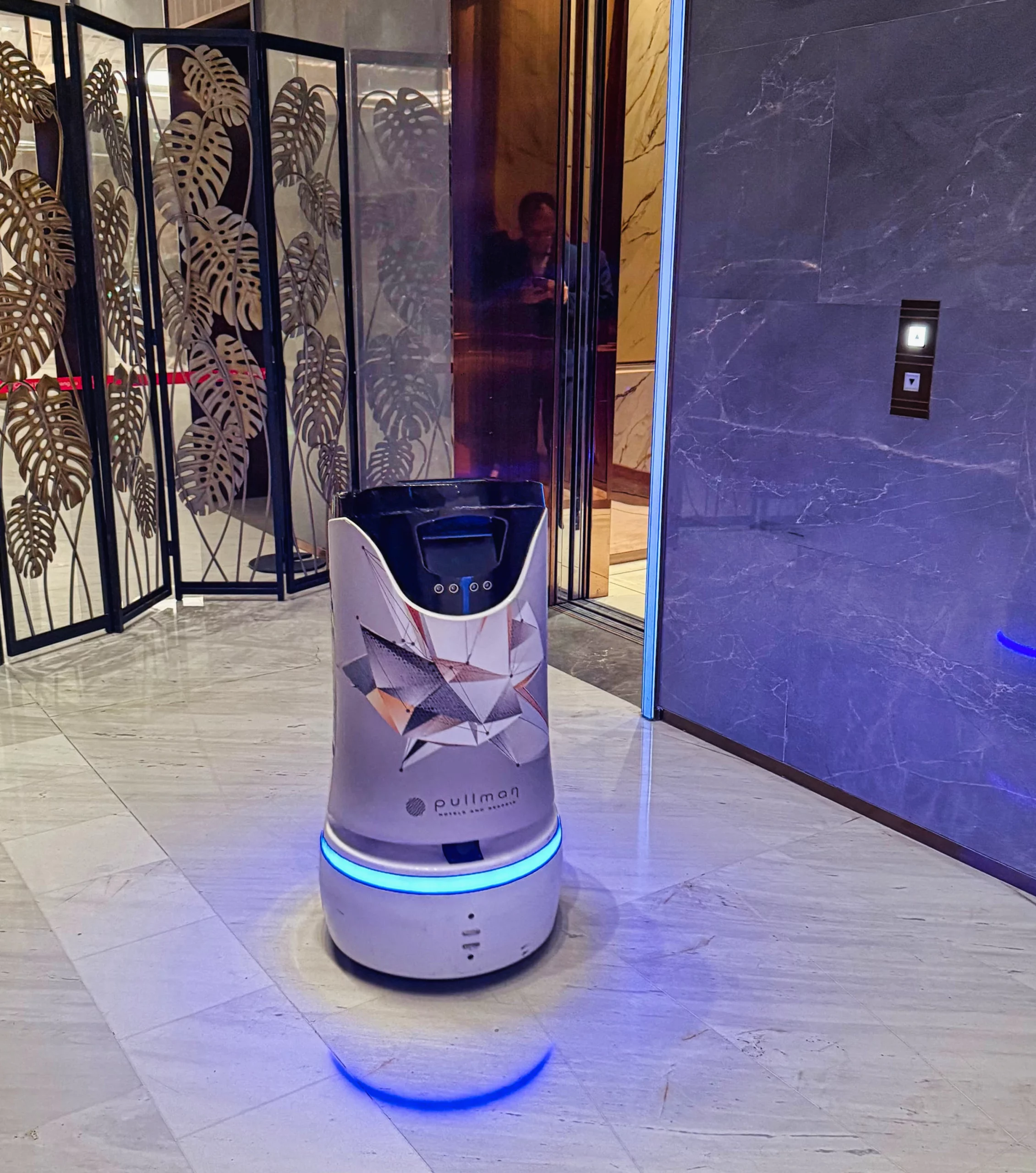 A small delivery robot in the hotel lobby.