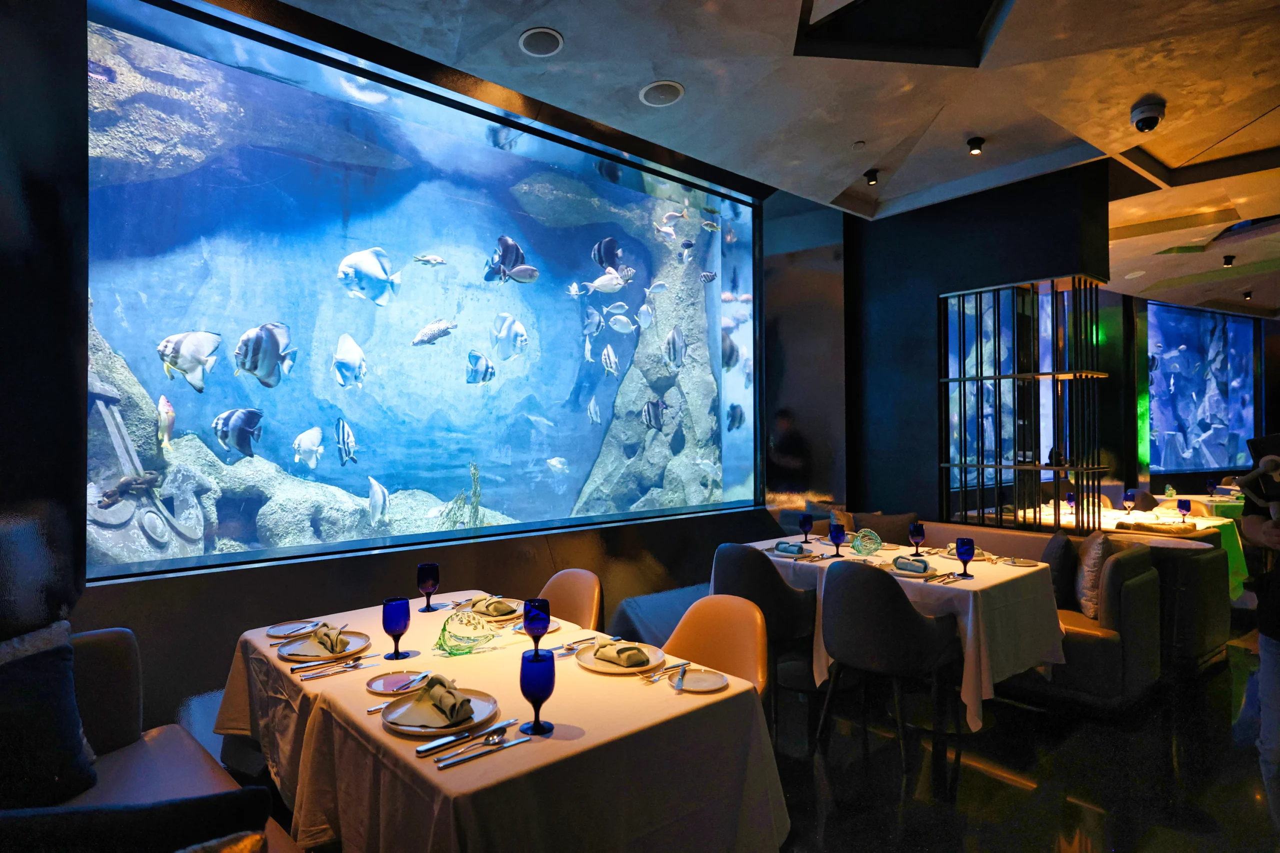  Interior of an underwater-themed restaurant with an aquarium wall.