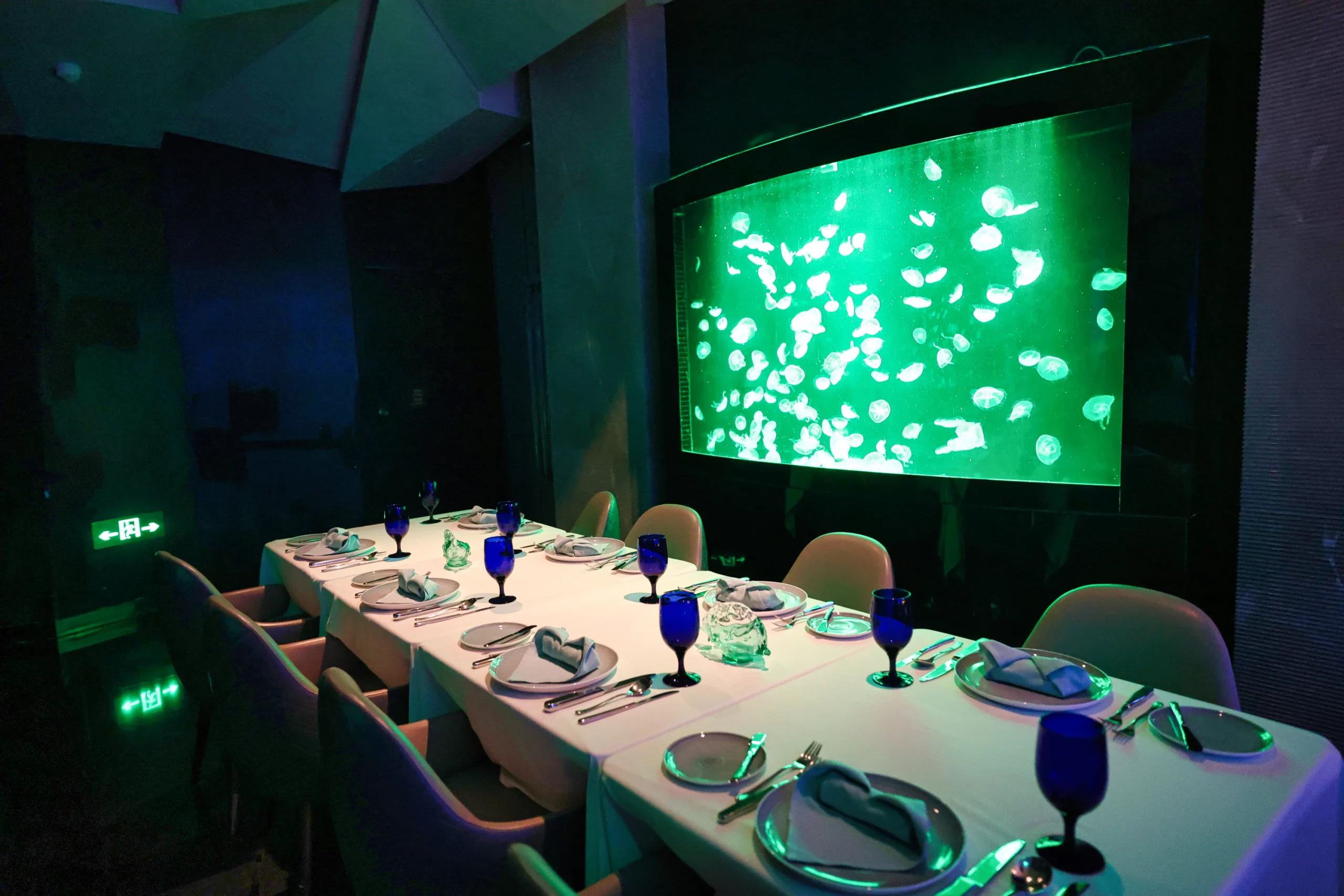  Interior of an underwater-themed restaurant with an aquarium wall.