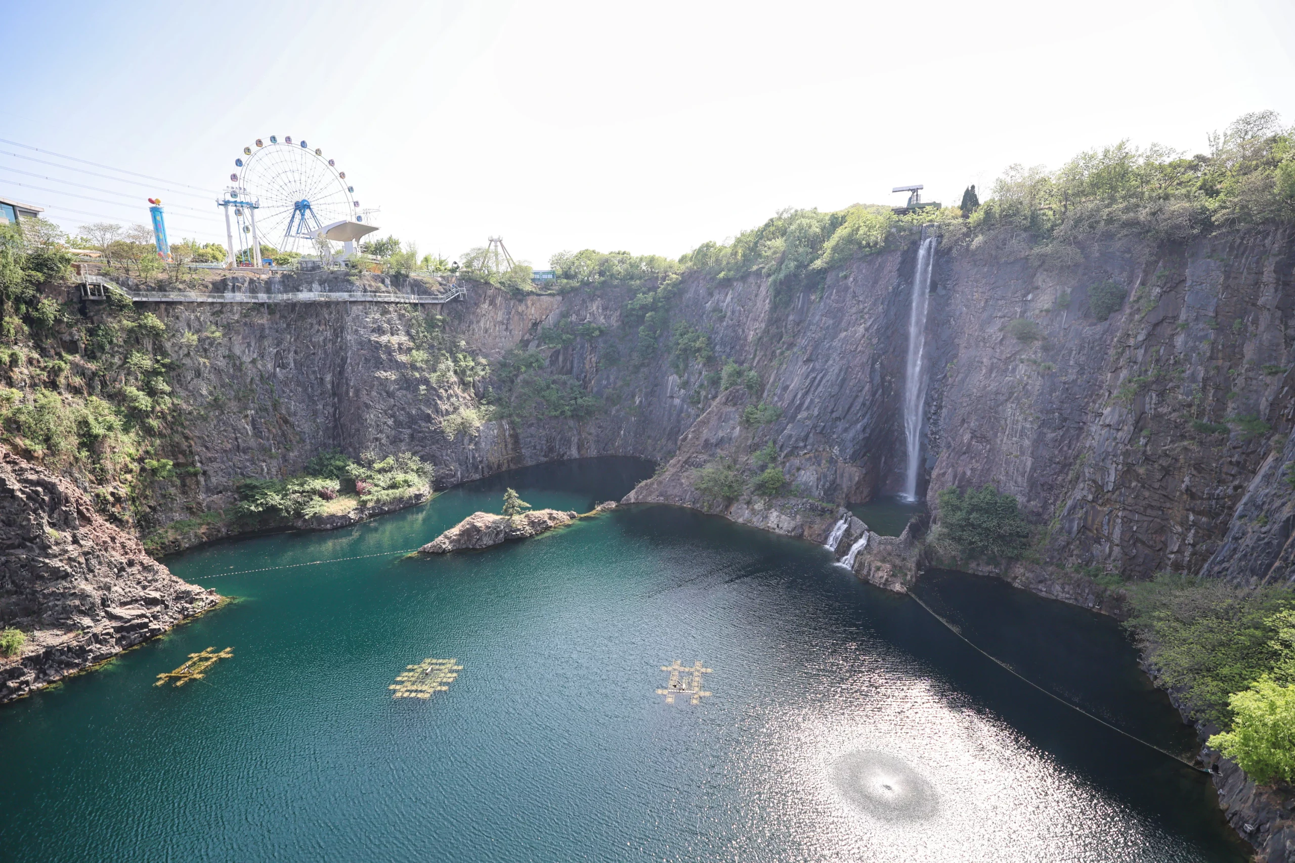 Hotel balcony with a scenic view of a waterfall and lake.