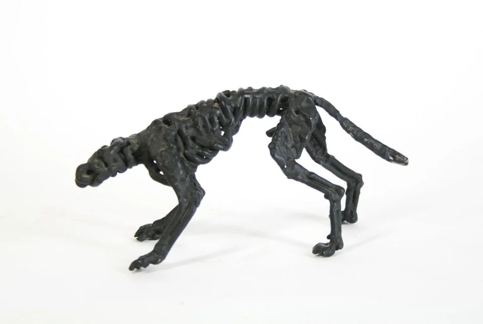 A small dog formed from twisted dark steel wire.