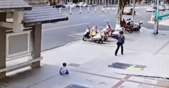 男童蹲地想討抱抱。(圖/翻攝自微博)