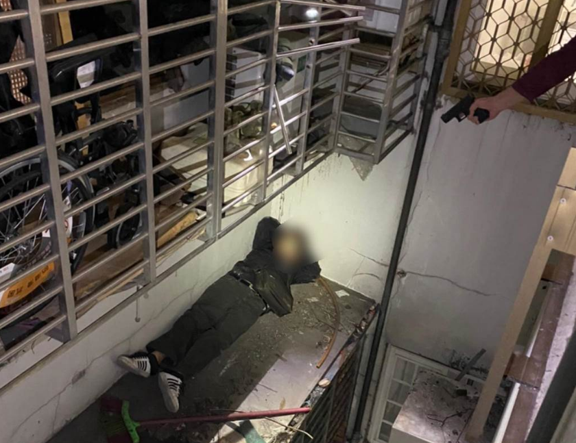 警方將逃入幼兒園的許、翁兩嫌帶回屋內清查，也在後陽台屋外遮雨棚找到卡在遮雨棚「進退兩難」的吳姓犯嫌，他被警方用槍指著，表情相當尷尬（翻攝照片／戴上容新北傳真）