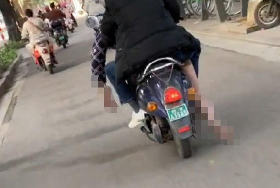 機車載運的遺體右腳在地上一路拖磨。(圖/翻攝馬來西亞《中國報》)