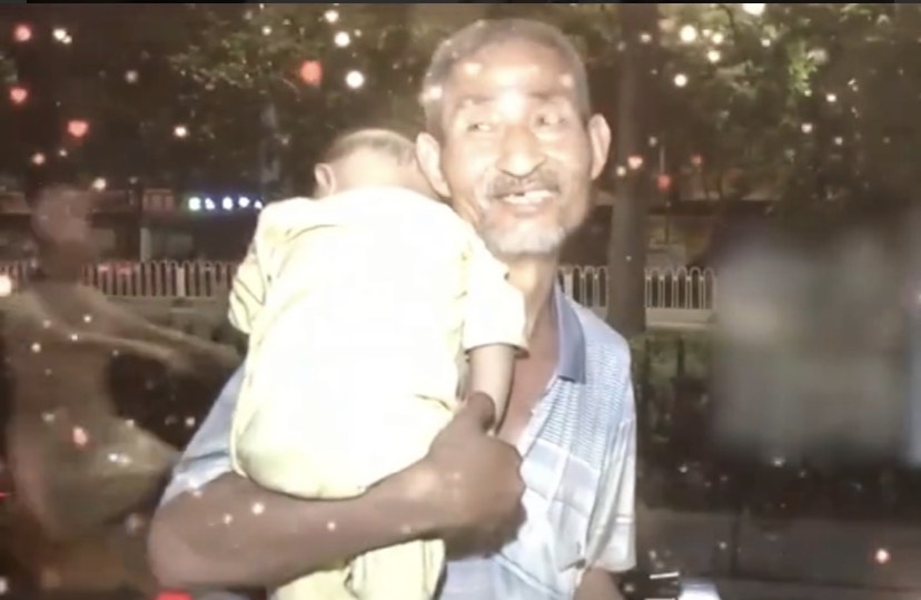 一名七旬老翁在深夜背著嬰兒撿垃圾的畫面引起廣泛關注。 (圖/翻攝微博)