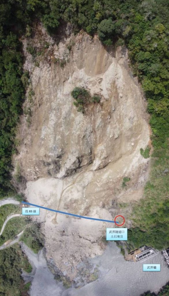 投83線25K武界隧道口上方的山壁邊坡,7日不幸發生大規模崩塌,大量土石滾落而下直接掩埋道路、中斷交通,且經縣府評估因崩塌量體太大,更因鄰近武界水壩,恐危及壩體安全,目前需暫緩開挖,修復計畫得再研擬。(圖/由中天新聞提供)