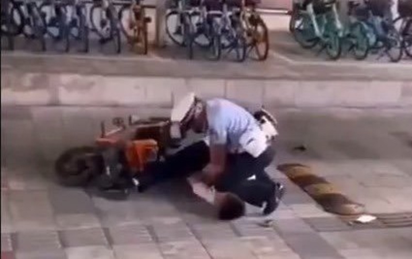 中國大陸廣州警察「以膝壓脖」,壓制一名電動車駕駛,引發社會不滿,質疑警方是否執法過當,更有人形容是大陸版的「佛洛伊德事件」。圖/翻攝推特