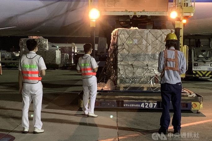 我國自購108萬劑莫德納疫苗運抵桃園國際機場，由地勤人員進行卸貨。中央社