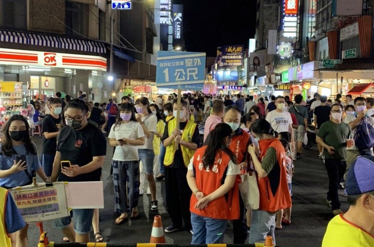 中秋節連續假期第3天，嘉義市文化路夜市20日晚間湧入滿滿人潮，嘉義市政府人員在夜市各路口進行管制及舉牌宣導，提醒民眾做好防疫措施。（嘉義市政府提供）中央社記者黃國芳傳真