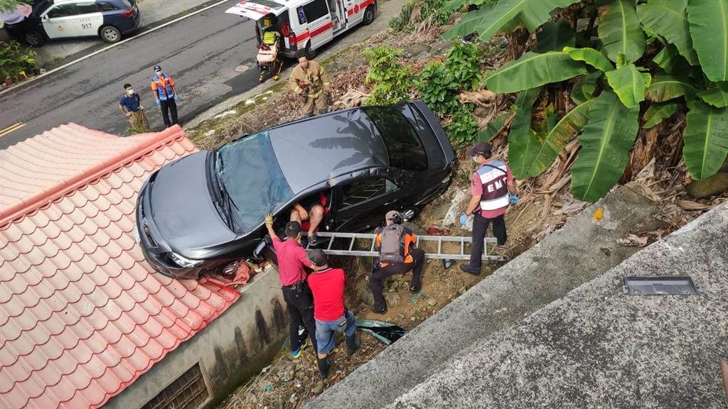 台南1輛轎車突然滑落邊坡，卡在民宅屋頂上。（圖／警方提供）