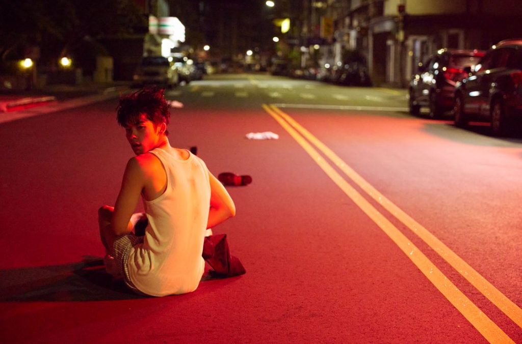 許光漢坐在大馬路上穿褲子。(圖/何樂音樂提供)