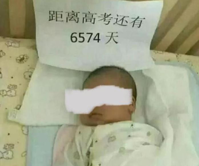 近日大陸網路上瘋傳一張「新生兒圖」，一名嬰兒背後的嬰兒床上竟貼著一張白紙黑字：「距離高考還有6574天」，引發熱議。（圖／翻攝自微博）