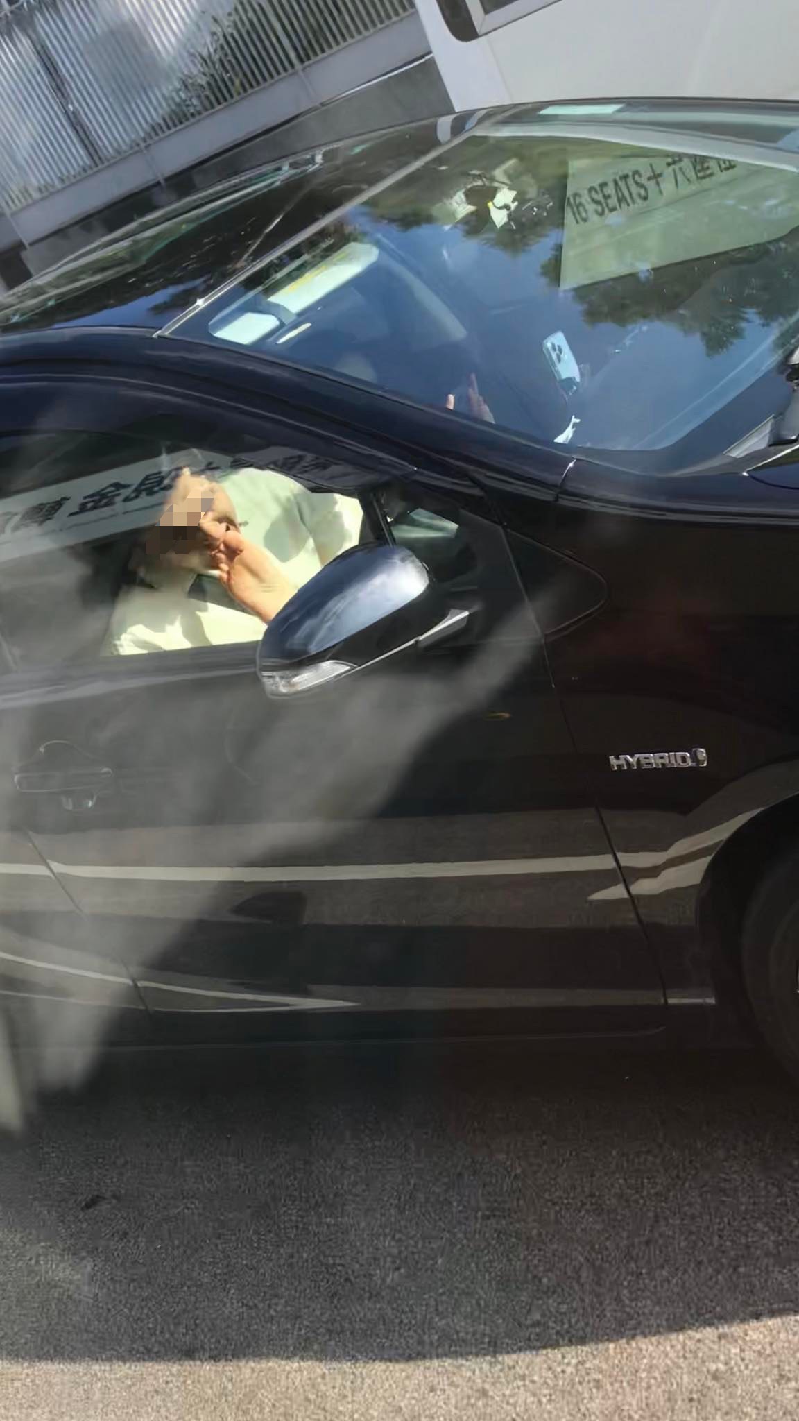 ▲黑車白衣駕駛,竟沒有專心開車,瘋狂的吸吮副駕女伴的腳趾,看起來非常樂在其中。(圖/翻攝自臉書社團《筲箕灣西灣河關注組》)