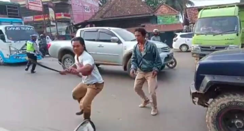 印尼南蘇門答臘（Sumatera）一名少年，日前因騎乘摩托車時違反交通規範，被當地執勤員警攔截，沒想到位於後座的老爸聽聞要開罰後，竟氣得衝下車，並拔刀要追砍該名員警。（圖／翻攝自推特）