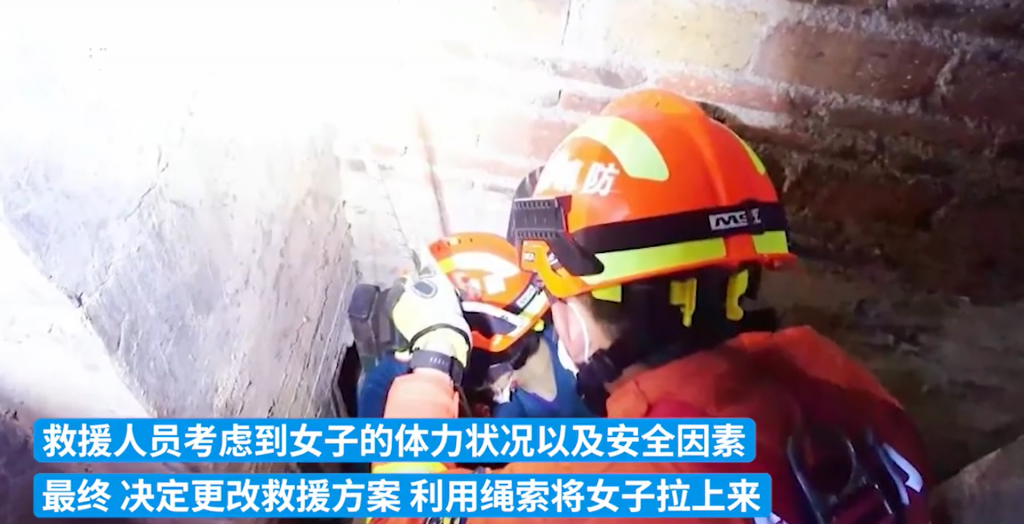 消防人員合力將受困女子從牆縫中救出。(圖/翻攝自微博)