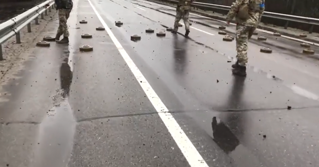 烏克蘭士兵把地雷踢到路邊。(圖/翻攝自推特/@IAPonomarenko)