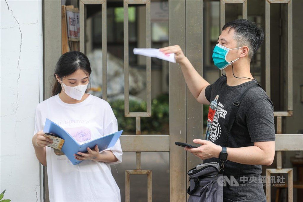 111學年度大學分發入學管道12日放榜，受到少子女化影響，今年缺額達1萬4493名。圖為7月天氣炎熱，家長在分科測驗試場幫孩子搧風降溫。（中央社檔案照片）