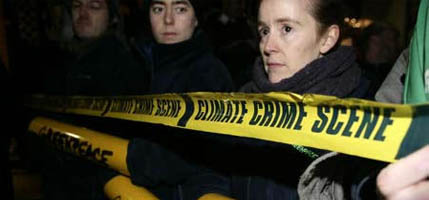 Volunteers hold "climate crime scene" tape