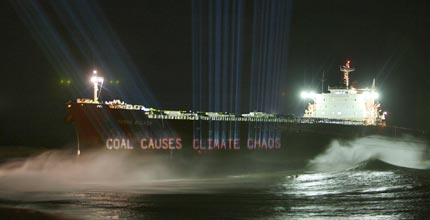 Greenpeace projects the words 'Coal causes climate change' onto the side of a coal transport ship in Australia