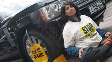 A Greenpeace volunteer on the Land Rover forecourt