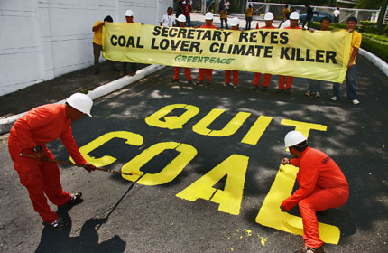 Greenpeace activists paint the message 'Quit Coal' on the driveway of the Department of Energy today in Fort Bonifacio, Taguig City, Philippines