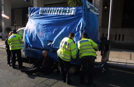 Activists locked underneath a trucked parked outside Oil & Mone