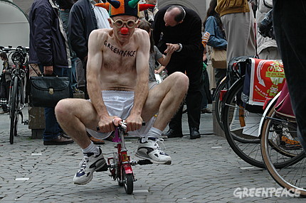 A naked man rides a very small bike