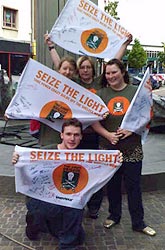 Volunteers in Blackburn with Seize the Light flags signed by Woolworths customers