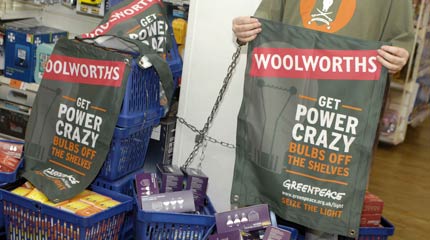 A Greenpeace volunteer locked on to baskets of inefficient light bulbs