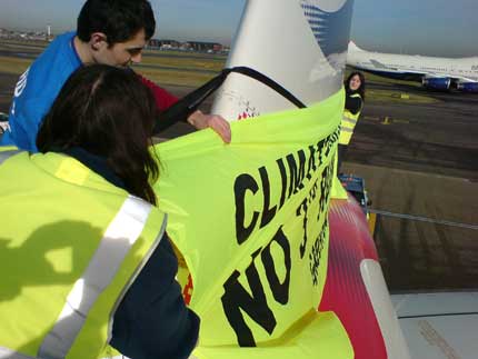 Greenpeace campaigners unfurl a banner on the tailfin