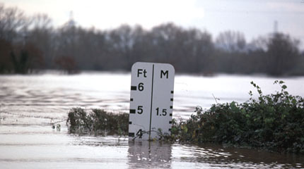 A flood reaches almost four feet high on a flood height marker