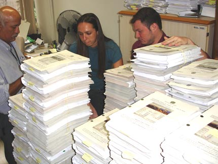 Staff at the federal prosecutor's office surrounded by legal documents relating to the hacking fraud