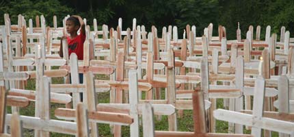 A boy stands among the crosses erected to commemorate the first anniversary of the murder of Sister Dorothy Stang