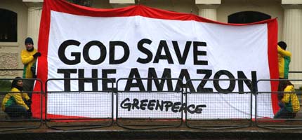 Greenpeace protesters demonstrate as the Queen and President Lula pass by during his state visit