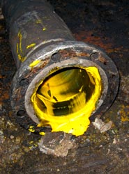 Crude palm oil seeping from a loading pipe © Greenpeace/Woolley