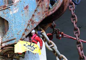 A Greenpeace protester hangs a banner from an oil rig in Cromarty Firth, Scotland