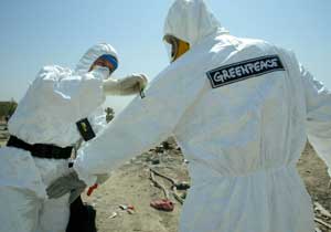 Greenpeace team members decontaminate eachother