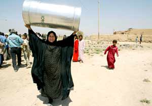 A Tawaitha woman carries a Greenpeace water barrel