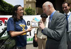 A Greenpeace campaigner presents EU Trade Commissioner Pascal Lamy with contaminated soy.