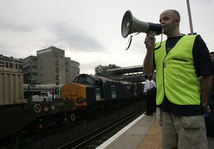 Greenpeace activists warn commuters about a nuclear waste train passing through Kensington Olympia