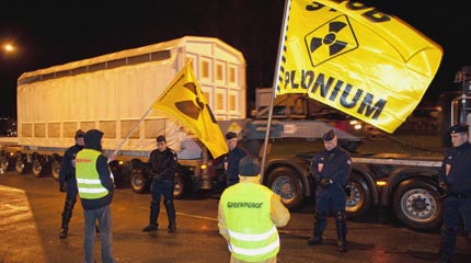 Greenpeace volunteers protest as a container of plutonium nuclear fuel is driven past in Cherbourg, France