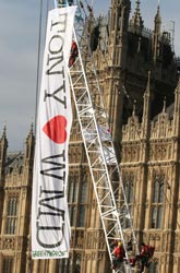 A banner hung from a crane outside parliament reads Tony heart WMD