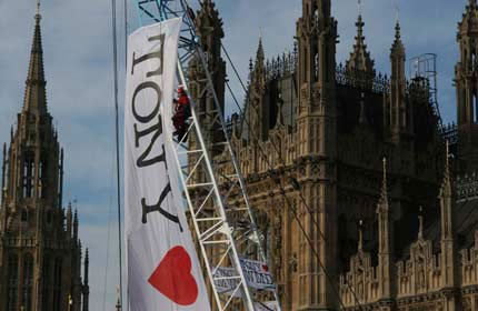 Greenpeace climber with Tony heart WMD banner