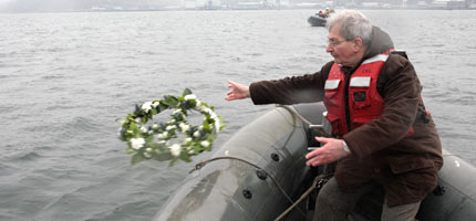 The Reverend Ainslie Walton casts a floral peace symbol into the waters outside Faslane nuclear weapons submarine base