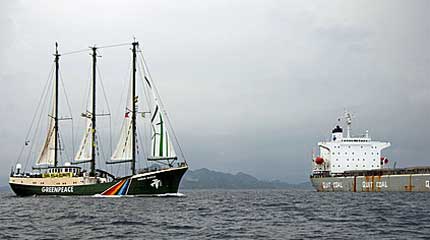 Greenpeace flagship Rainbow Warrior passes by the coal ship Sam John Spirit as it exits the Pagbilao coal-fired power plant pier in Quezon Province, 150 kilometers south of Manila.