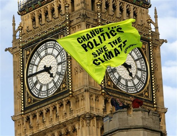 Greenpeace action, 2009 - protester waving a flag on top of Parliament  